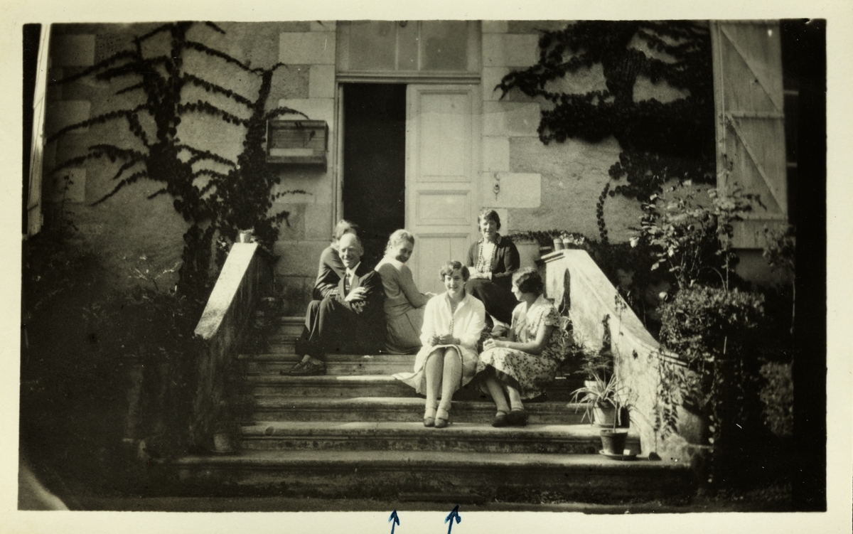 En eldre mann og fem unge kvinner på trappen til en stor murbygning(skole?). De to pilene under bildet viser til venstre Stina og til høyre Signe Hille, muligens medstudenter til Lucy Egeberg i Frankrike. Fotografert høsten 1926,