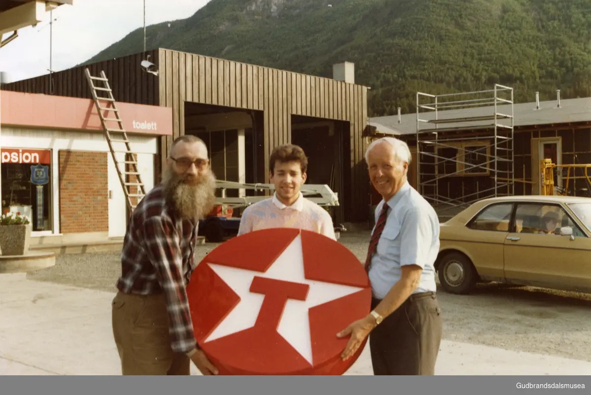 Markering av 25-års jubileet for Texaco-stasjonen på Dovre i 1985. Fra venstre grunnleggeren Arne Haugerud, sønnen Arne Henning og Torgeir Bjørstad, direktør for detaljhandel i Norsk Texaco.