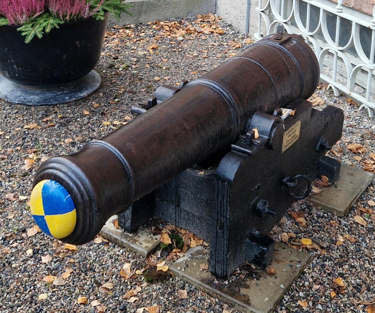 Kanon med mässingsskylt: "Kanon 1 ( 2 ). Tillhörande: föreningen Sundsvalls Gille." Blå/gul träplugg i kanonröret. Kanonen står skyddat på fyra betongplattor 35 x 35 cm:s med plåtbit + najtråd. En engelsk fartygskanon i gjutjärn, tillverkade av Baely Pegg & Company omkring år 1800. Kaliber 10 cm. Enkel trälavett. Kanonen är märkt B PoC och nr 830. Sundsvalls Gille erhöll den (tillsammans med MFF15233) som gåva av Sundsvalls hamn 1953. Meningen var att kanonerna skulle ställas som ett monument intill Widesbron riktade mot varandra, till minne av det ryska anfallet på Sundsvall 25 maj 1721. Av okänd anledning blev inte detta utfört och de placerades på Norra stadsberget och sedan framför den gamla Vinfabriken där de stod under många år. 