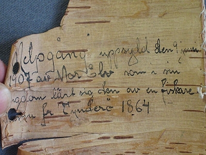 Prov på spetssöm, sk. melpagång, uppsytt på en bit näver. På baksidan av näverbiten står skrivet med svart bläck:

"Melpagång uppsydd den 9 juni 1907 av Mor Elv som i sin ungdom lärt sig den av en fiskarehustru fr Tynderö 1864".