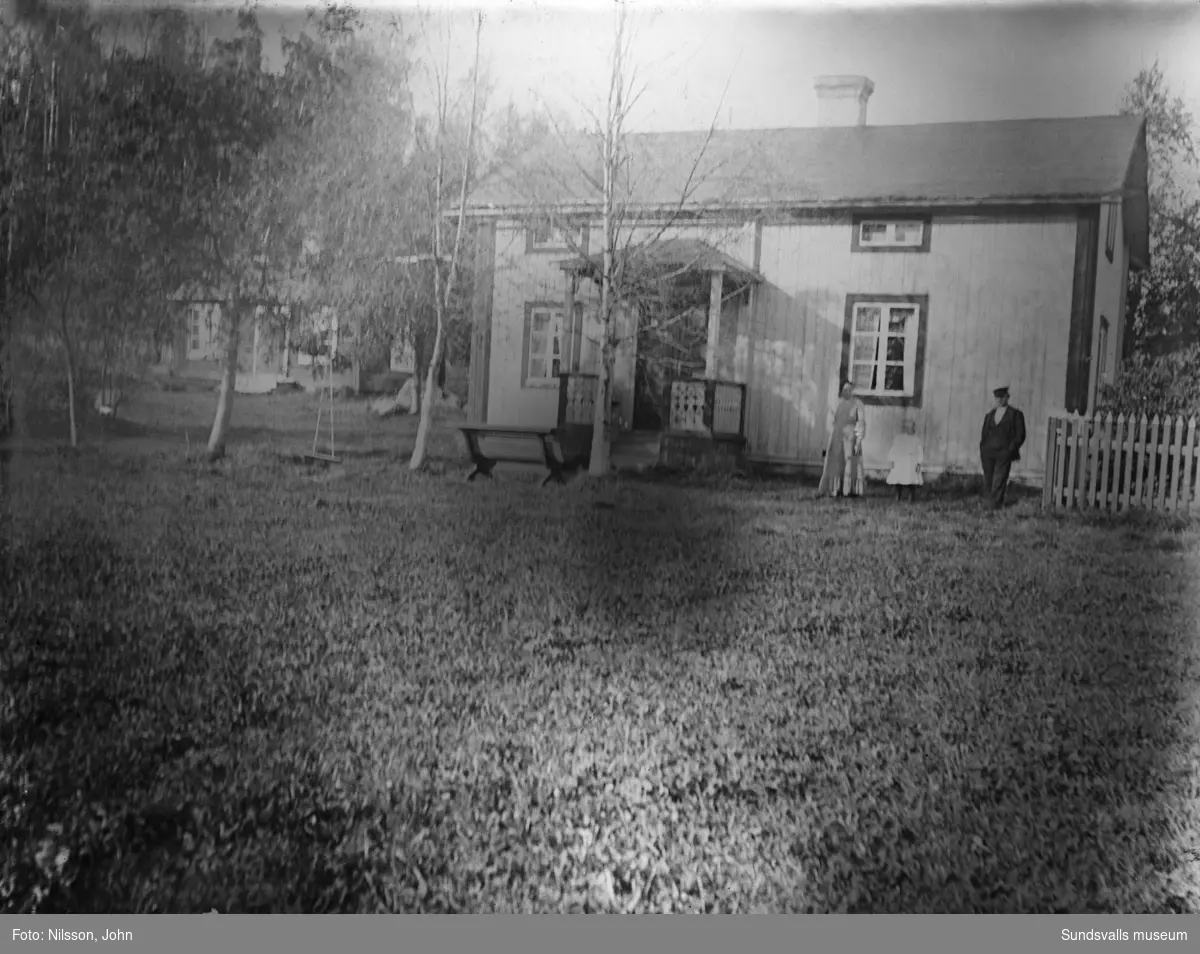 En kvinna, en man och en flicka framför ett ljusmålat bostadshus, på bild två syns även brukstugan.