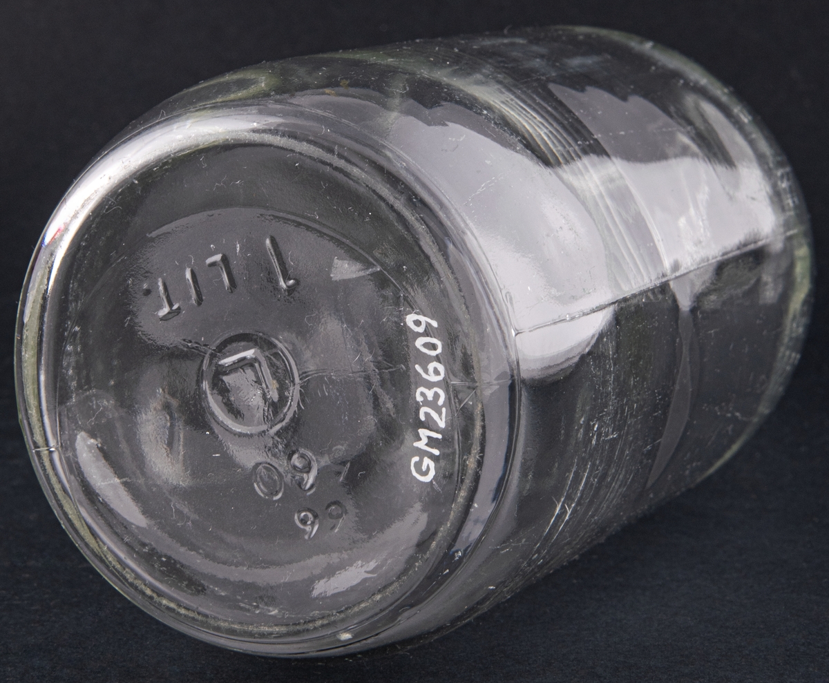 Butelj av ofärgat glas, Märkt under:" 6/60 L 1 LIT". Etikett saknas.