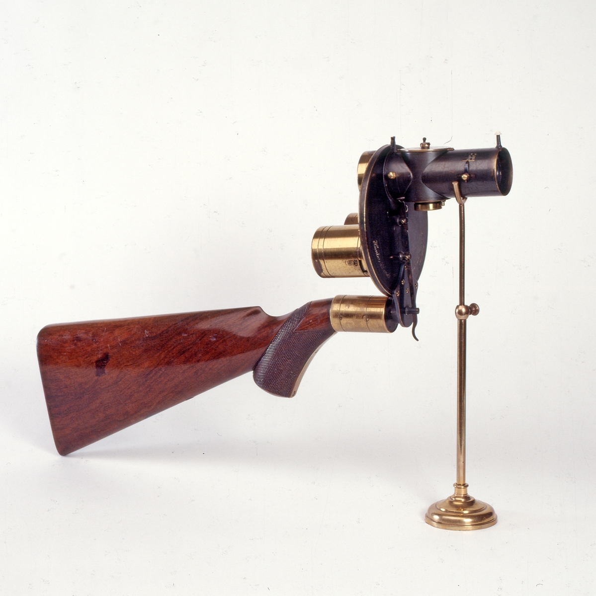 Tørrplatekamera formet som et gevær produsert av Londonbaserte Hunter & Sands i 1883. 
Kameraet holdes og siktes som et gevær. Det er utstyrt med to lagringssylindere for oppbevaring av glassplatene (før og etter eksponering). Platestørrelsen er på 1 ½” i diameter.    
Dette kameraet er et eksempel på et håndholdt kamera. Da tørrplatene kom i 1878, ble eksponeringstidene så korte at man kunne ta bilder med håndholdte kameraer og av ting i bevegelse. Tørrplatene kunne også lagres i magasinet. I dette kameraet er det plass til 18 plater. Firmaet skiftet navn til Sands and Hunter og kom med en ny modell i 1885.
