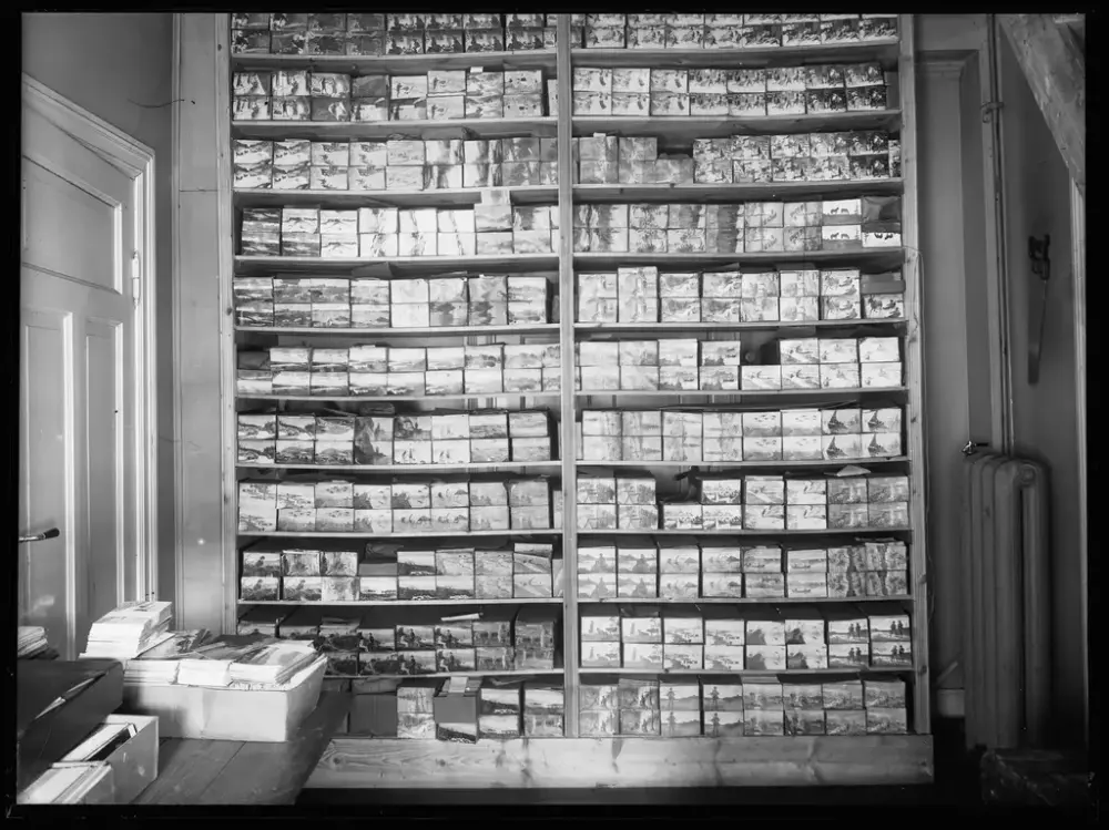 Shelves full of boxes with postcards stacked neatly on top of each other