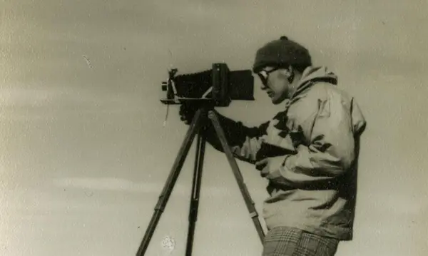 Photo shows a photographer with his camera on a tripod.