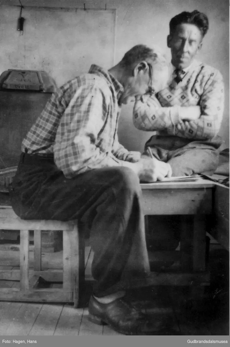 På anleggsarbeid i Glomfjord ca. 1950.  
Ditlef Rudsar (f. 1895) skriv brev til kona, Rikard Hosar (f. 1897) dikterer