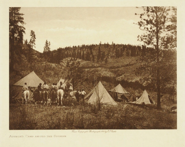 En leirplass i Spokane-reservatet, Washington, hvor Edward S. Curtis bodde under et av sine feltstudier for å dokumentere urbefolkningen i område. Til venstre i bildet har han fått med en gruppe Spokan-menn til hest.