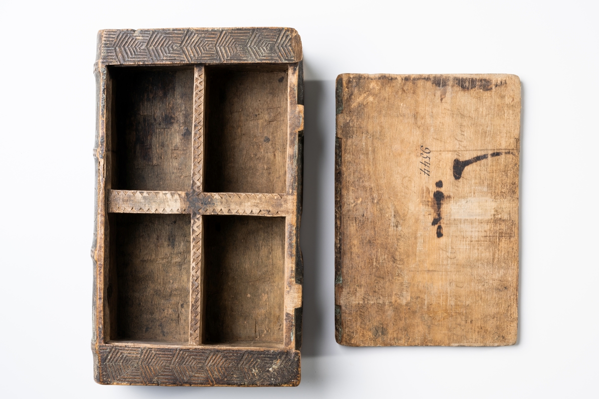 Kryddlåda av trä i bokform, ornerad. På ryggen skuret "1791" och "S C D".