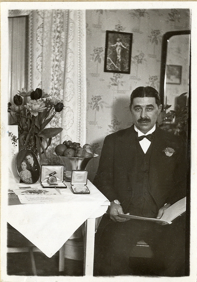 En man i kostym sitter vid ett bord med presenter och begrundar ett telegram,
10 april 1933.