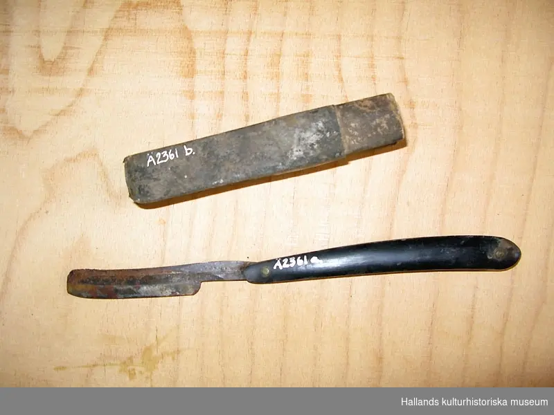 Rakkniv med etui av papp med två fack. Kniven av metall med skaft eller handtag av ben eller horn.