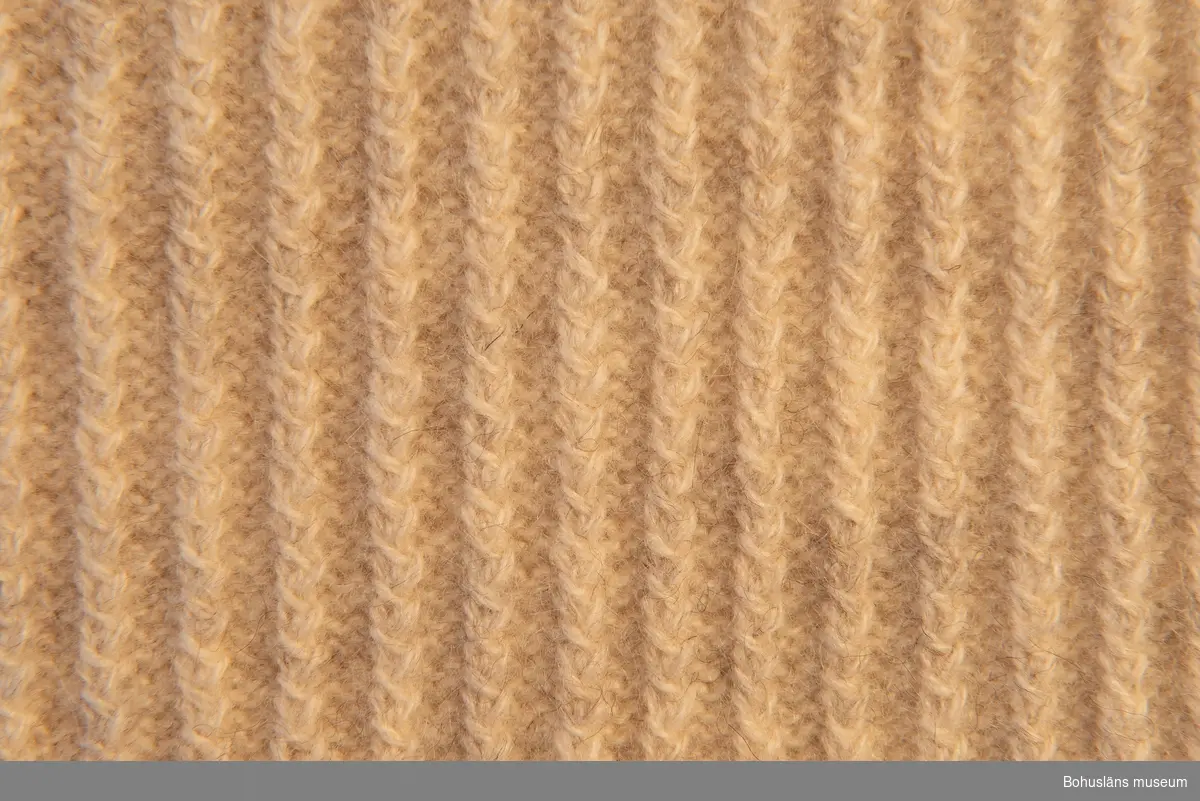 Herrslipover i mönster "Vridna randen" i naturvit finull efter mönster av Emma Jacobsson från tidigt 1940-tal.
Framstycket stickat i smala ränder (flätor).