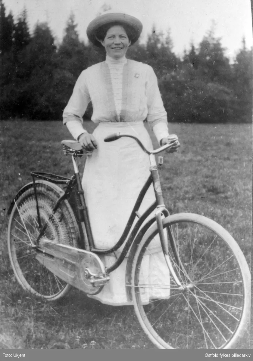 Portrett av Helene Eikaas fra Trøgstad og hennes sykkel. ca. 1915-20?