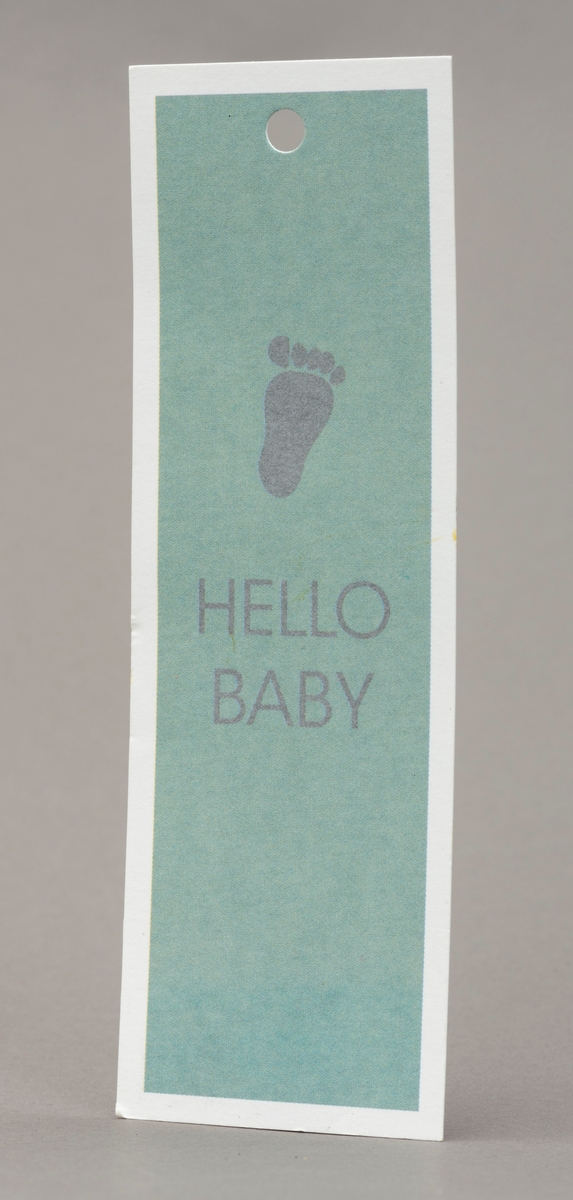 Gratulasjonskort, lysegrønt med sølvskrift "Helom baby" og barnefot. Hvit kant.