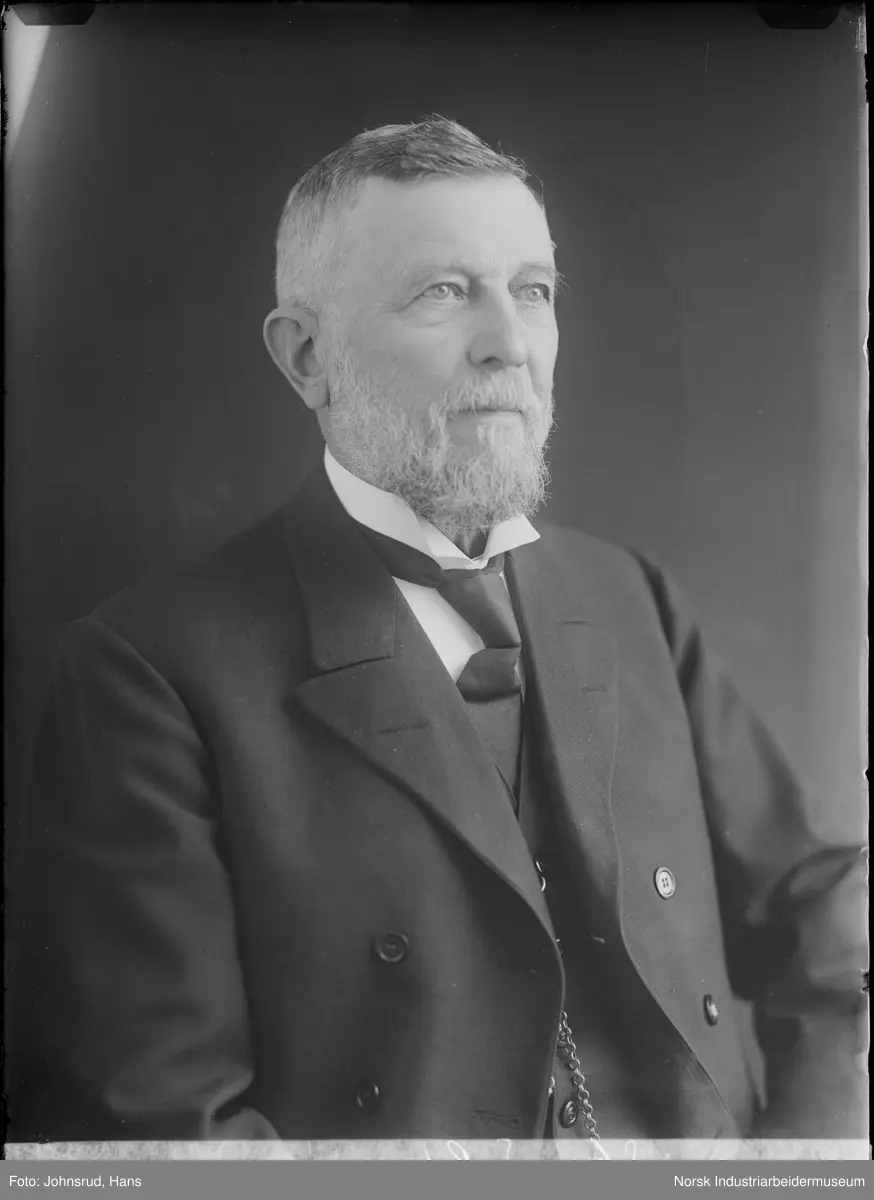 Portrett. Mann kledd i dress og slips fotografert i studio. Norsk