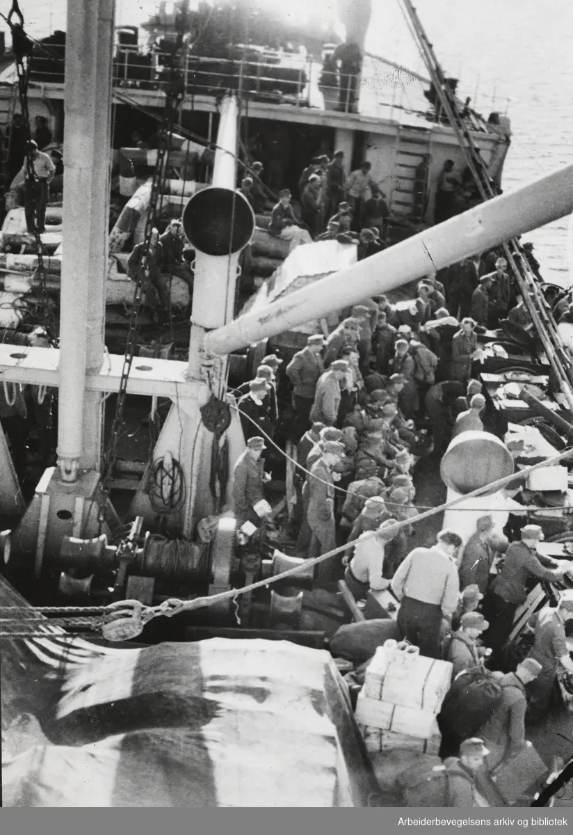 "4000 Tyskere forlater Norge". Bildet er tatt ombord i Den Norske Amerikalinjens D/S Drammensfjord utenfor Mandal, med kurs for Tyskland. Juni 1946