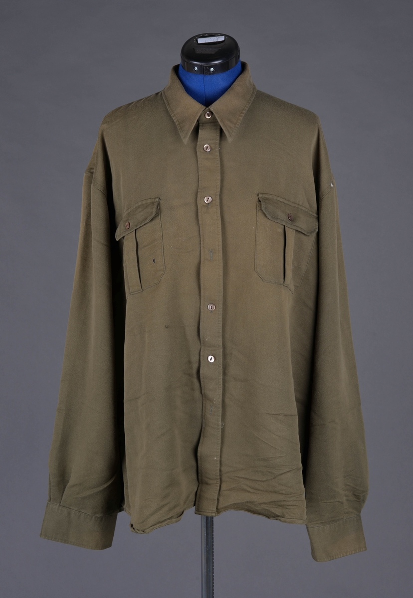Skjorte med snipper, knappestolpe foran og brystlommer med klaff.
Produsert av Dressmann, som startet opp i 1965, så har ikke vært en del av Lingeuniformen. Antatt å ha erstattet skjorter som ble brukt under krigen