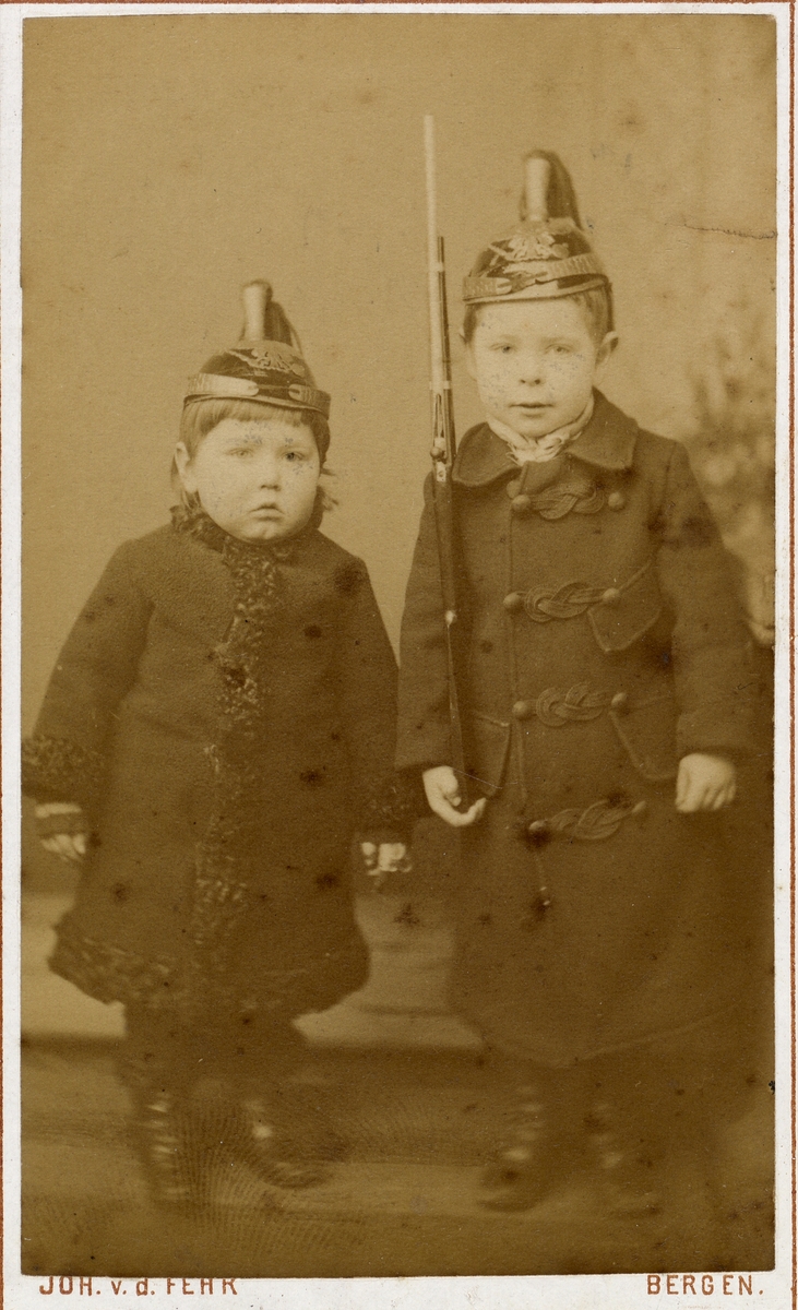 Barneportrett. To små gutter med hjelm og gevær.