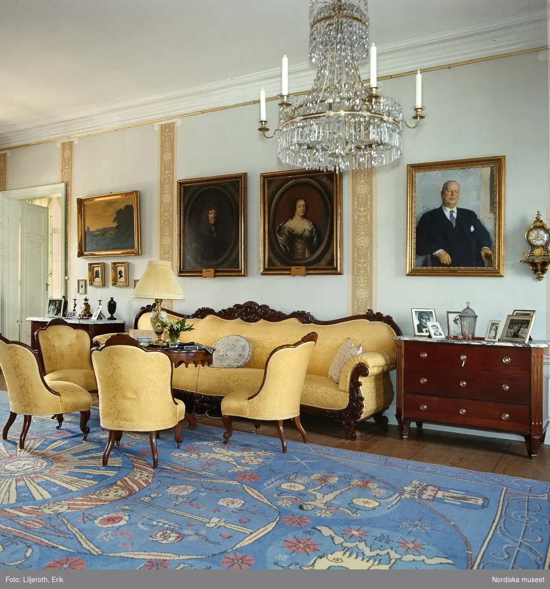 Interiör från Blekhem i Småland. Stora salongen med möbel i nyrokoko, matta vävd efter mönster av Maja Sjöström och Ehrenstrahlporträtt över soffan.