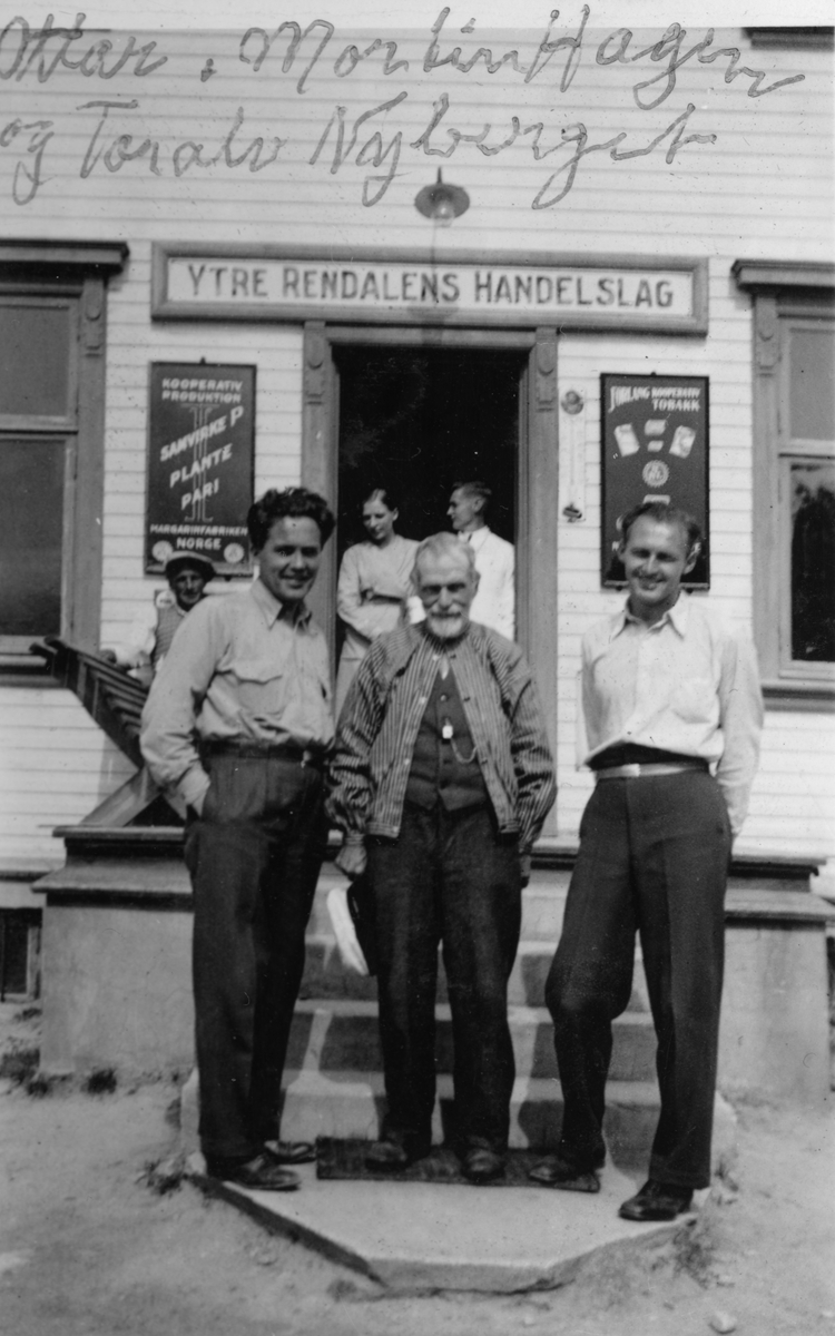 Tre menn foran butikk