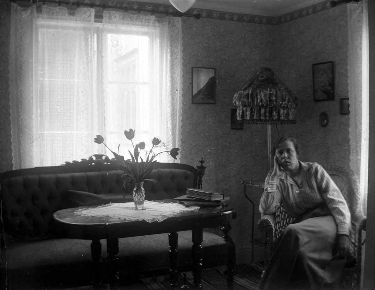 En kvinna fotograferad i ett vardagsrum.