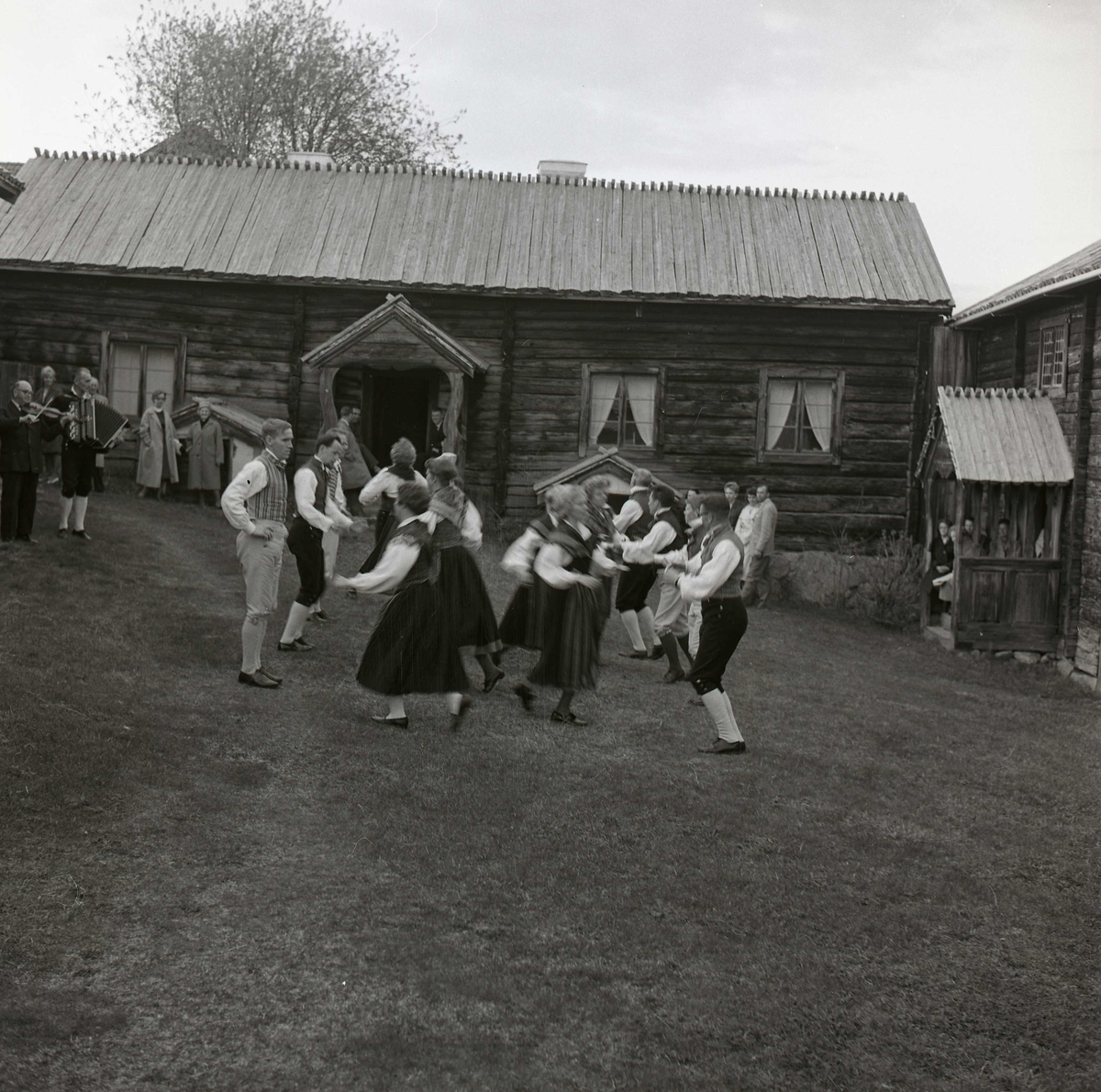Människor dansar iklädda folkdräkt framför en gård den 17 maj 1963.