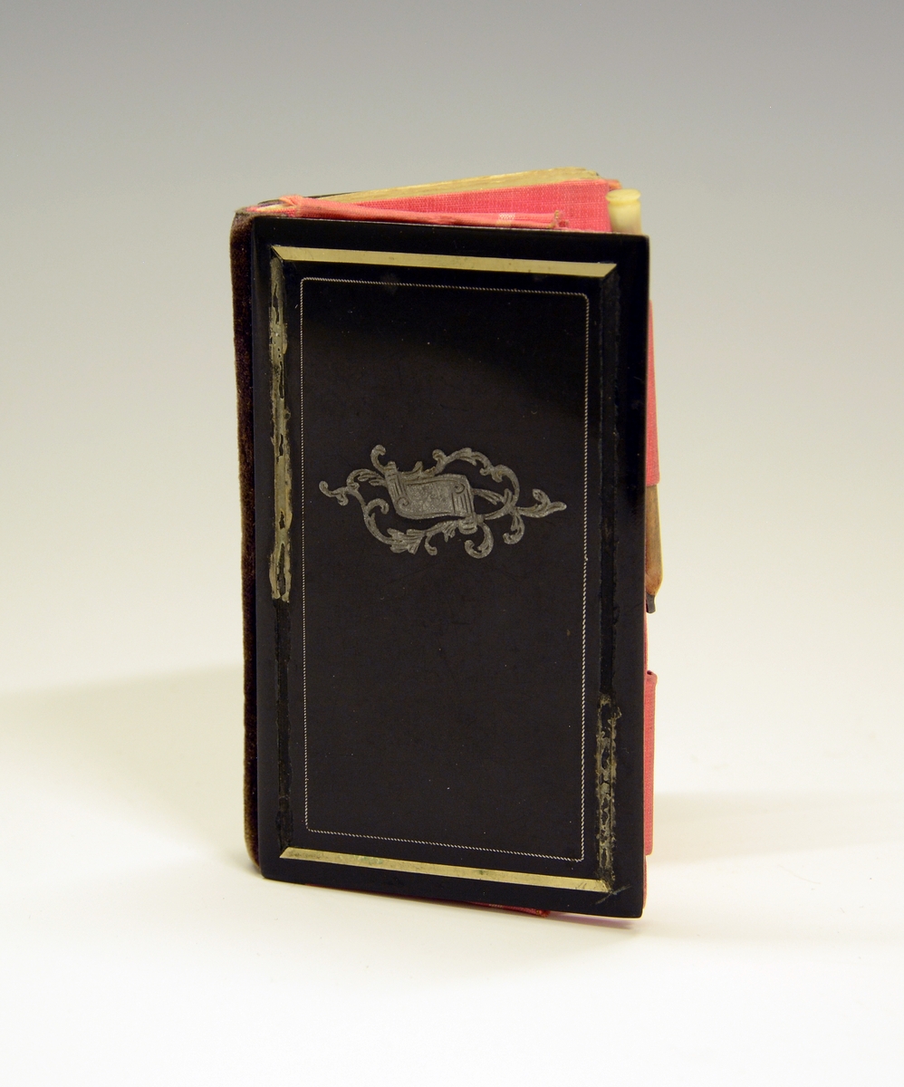Notatbok med blyant og kalender for 1850. Fra protokollen: Dagbok, kjøpt i Frankrike 1850 av frk. Benedicte Plesner. Med stive, svarte permer med gullrand som er vekk på langsidene.