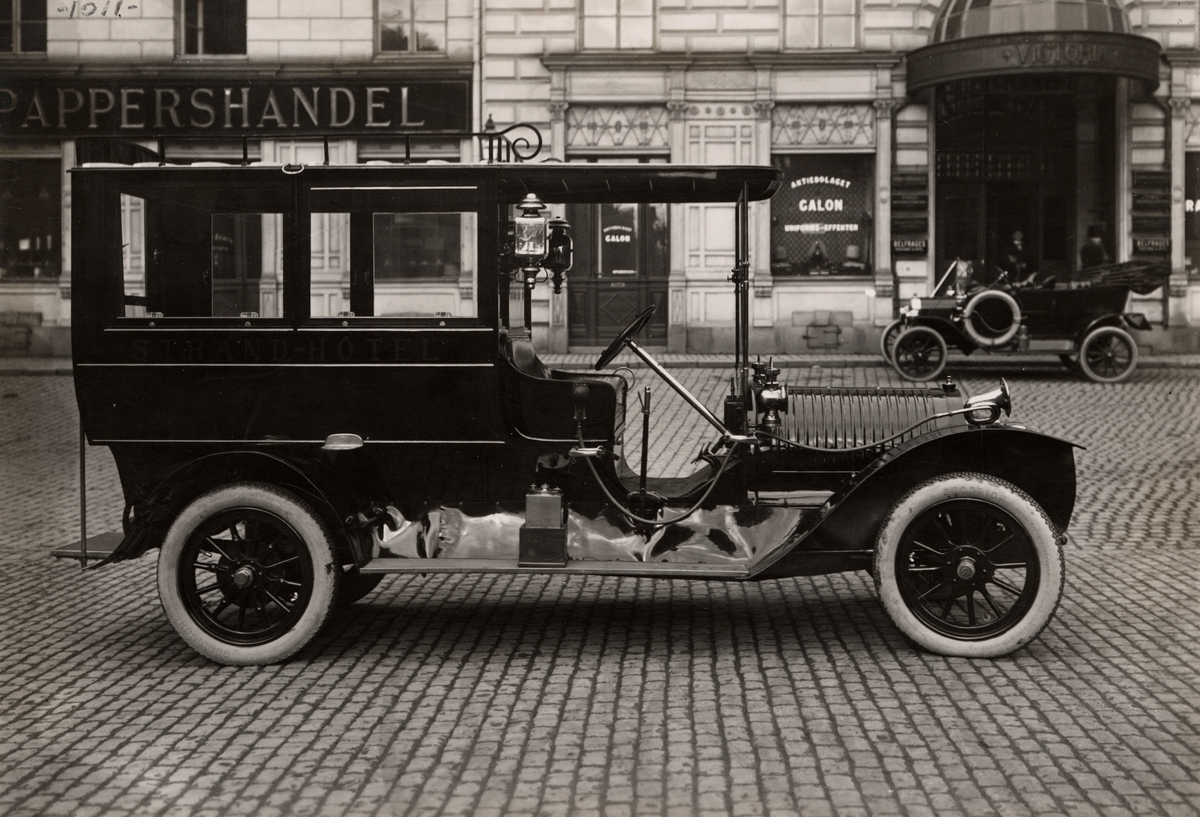 Automobil Georges-Roy. Karosseri tillverkat vid AB Stockholms Vagn- och Karosserifabrik. Specialbyggd kaross tillverkad för Strand Hotel i Stockholm och levererad 1911. Georges-Roy var ett ovanligt franskt märke som faktiskt såldes i Sverige under 1910-talet.