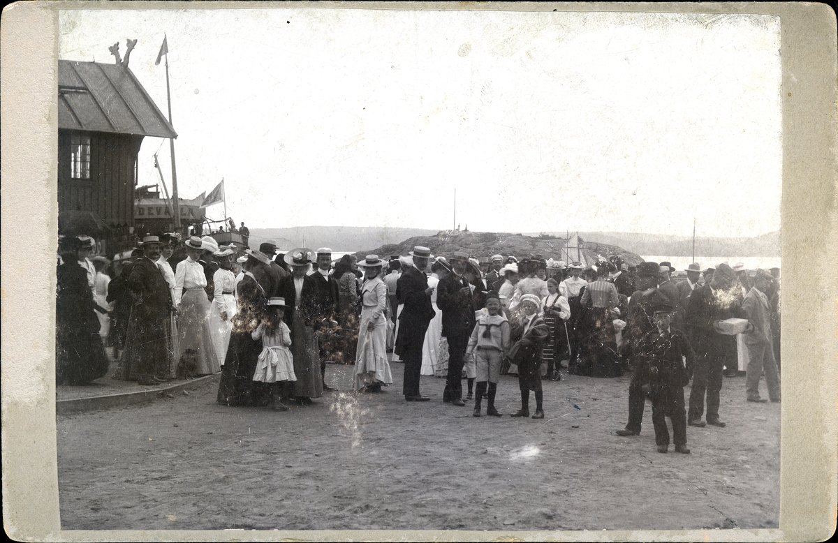 Folksamling i Lyckornas hamn med klocktornet och ångaren Uddevalla till vänster