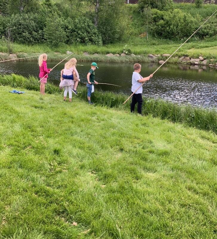 Barn fisker ved åa på Almenninga.