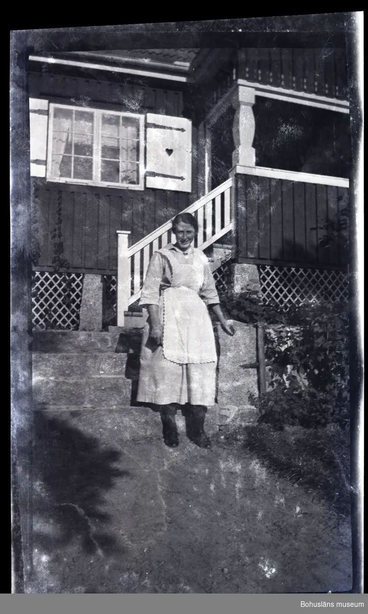 En person ståendes framför ett hus.