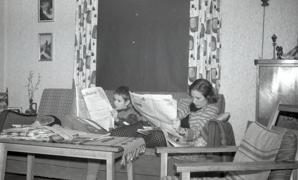 Lars Inge Jarl Askvik og Margit Askvik leser i aviser i stua i boligen på Haugen i 1957.