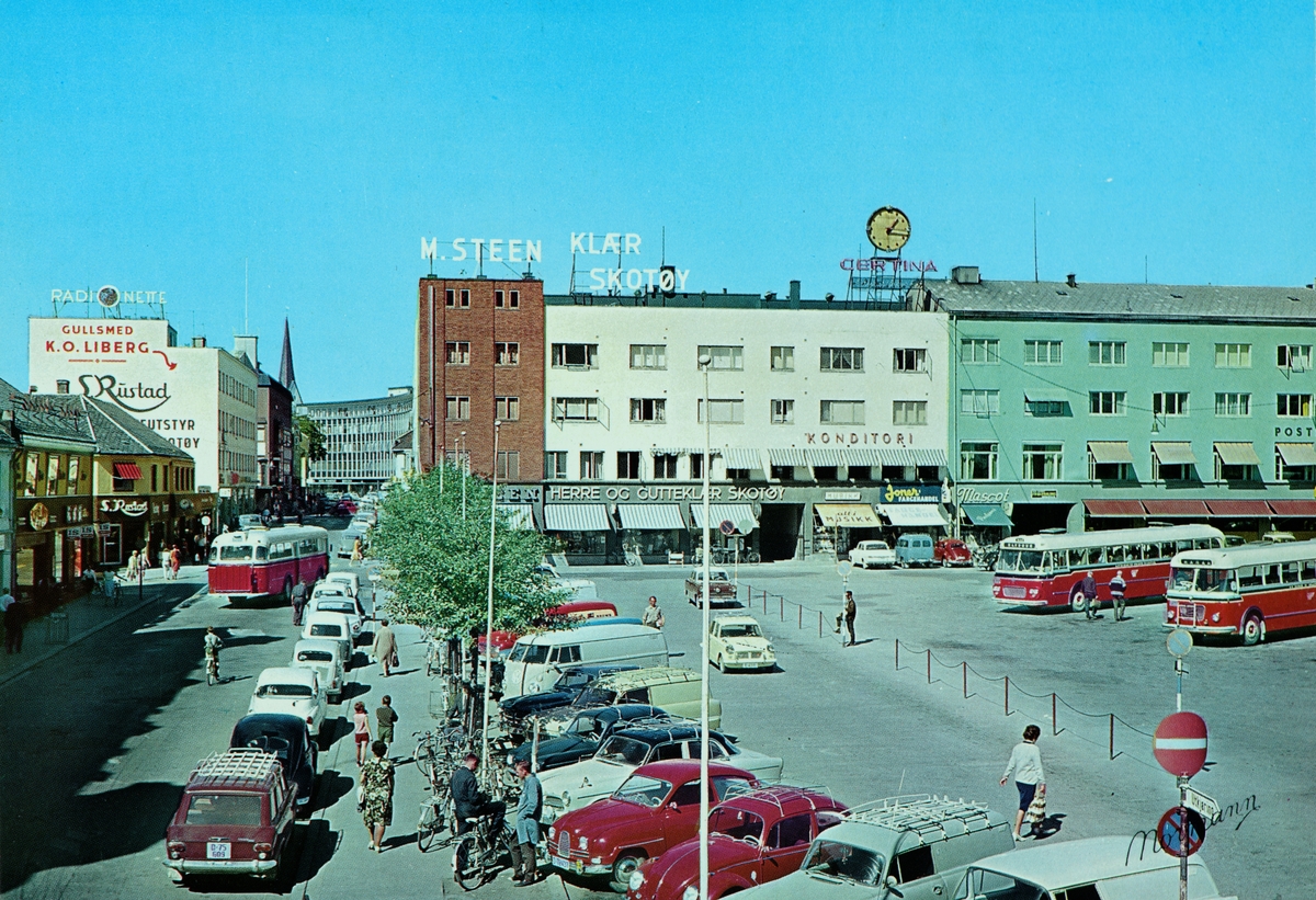 Postkort, Hamar, Østre Torg, Torggata 41, S. Rustad, M. Steen bygget, Posthusgården, rutebilstasjonen, Hamar og Omland Bilruter, parkeringsplass med biler,