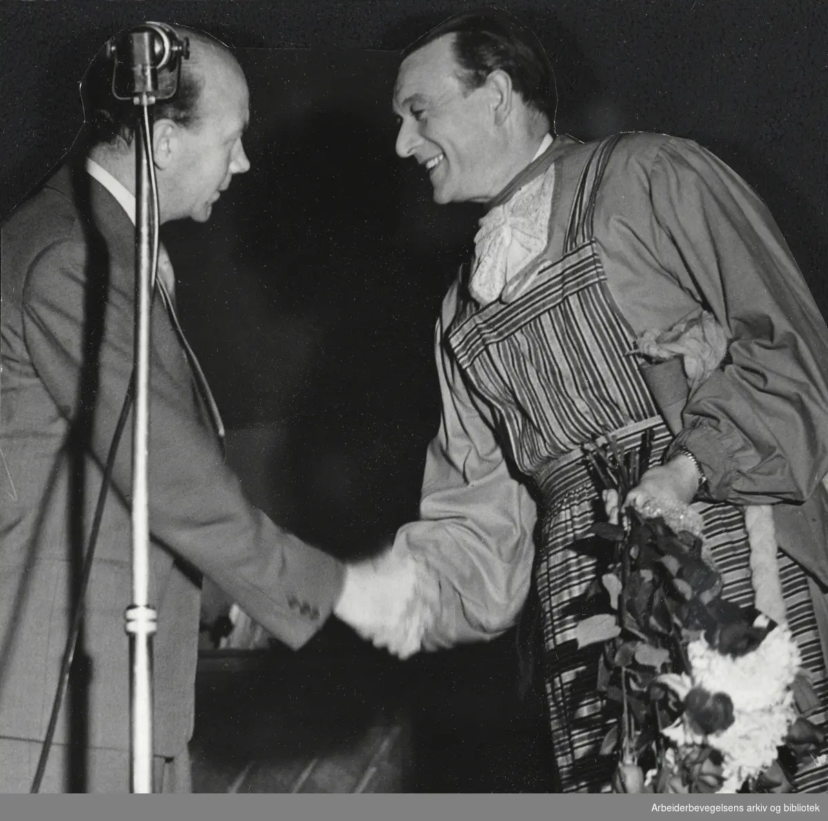 Formann i Oslo Arbeiderparti, Hans Sundrønning overrekker blomster til revyskuespiller Herbert Herding Herberth under et valgmøte i Lilleaker Folkets Hus før Stortingsvalget 1953