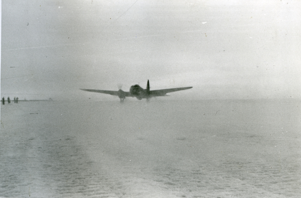 Et tysk Heinkel 111-fly lander i Adventdalen 21.april 1941. Det er det ene av to tyske fly som kom til Longyearbyen i slutten av april 1941 med brannslukningsapparatur, etter at det var brutt ut ild i Gruve 2 i Longyearbyen (info fra Kalde krigsår av Thorvald Lund). Bildet er fra albumet til Jens A. Bay, som bodde i Longyearbyen vinteren 1940/41.
