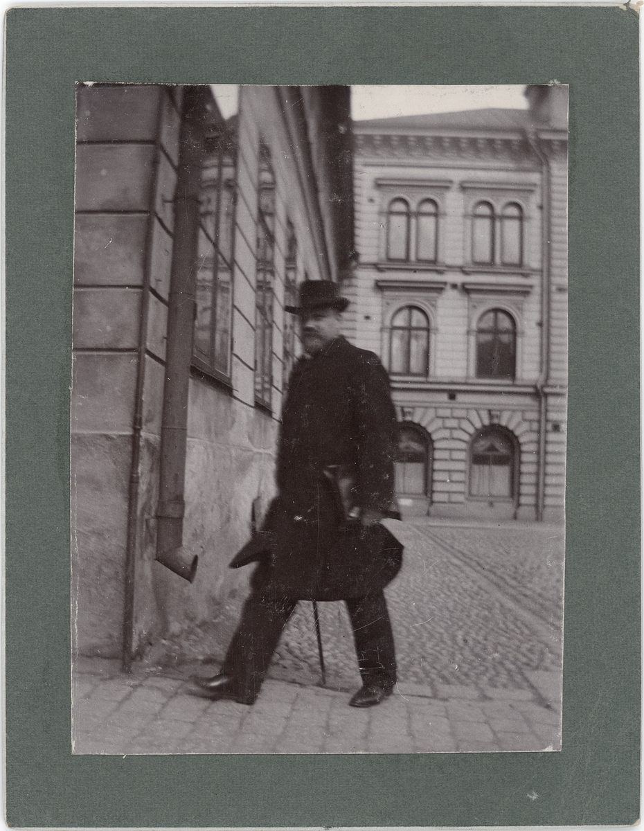 En man med portfölj under armen promenerar över Stora torget, kvarteret Kransen, Uppsala
