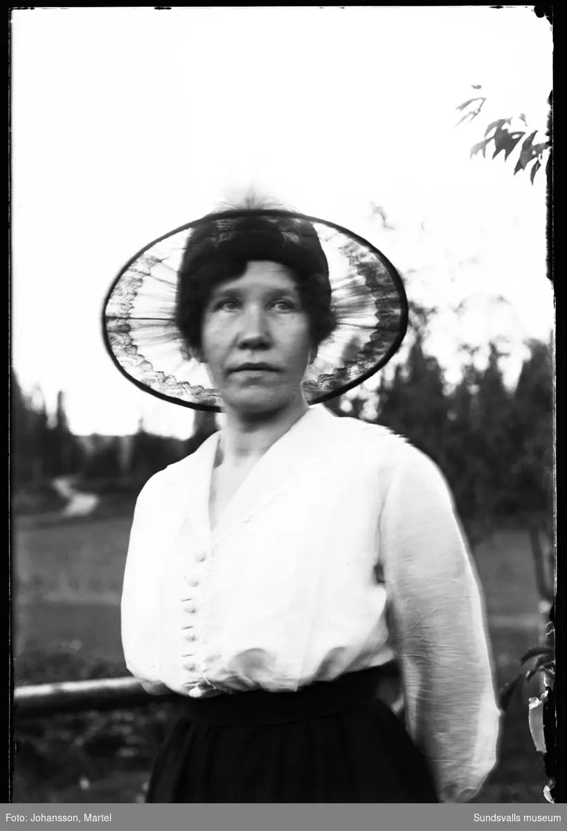 Porträtt av sömmerskan Klara Lindgren, Sörfors, iklädd en bredbrättad hatt.