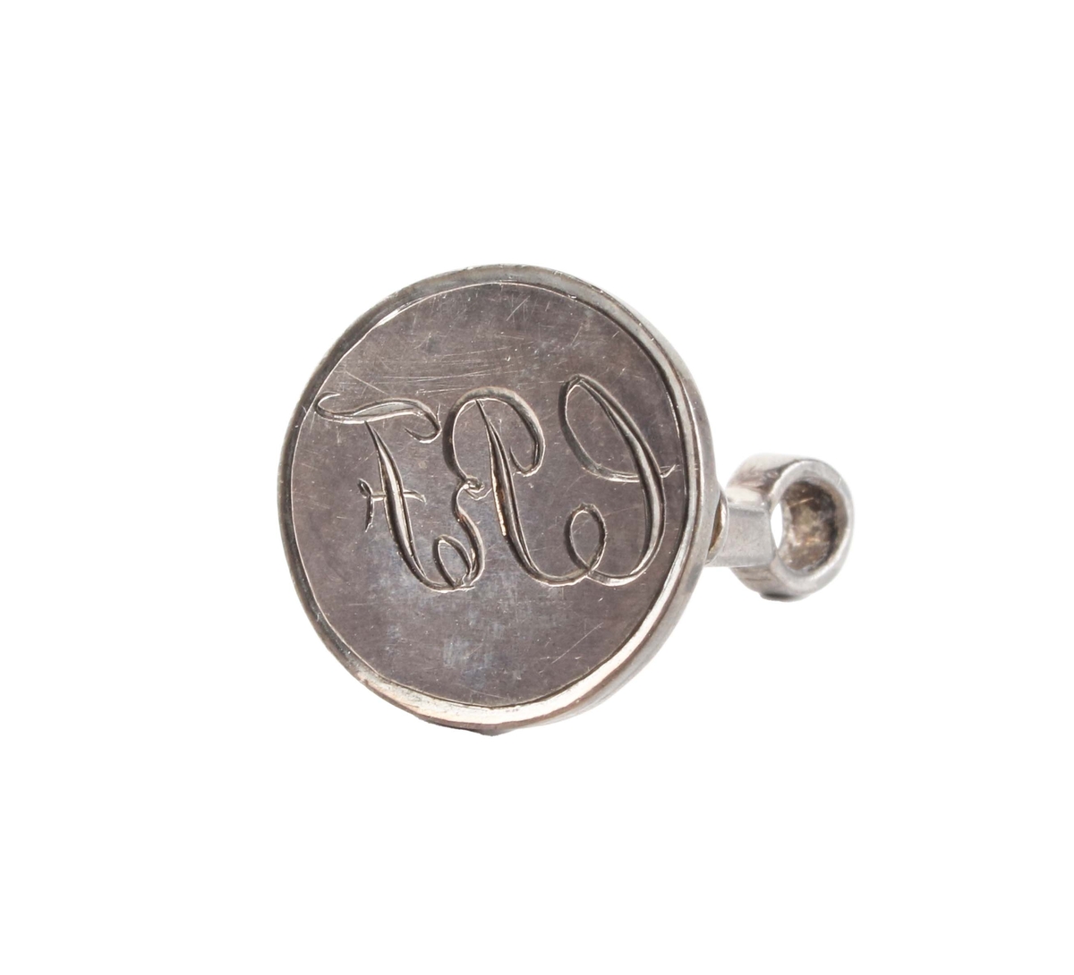Sigillstamp i silver. Oval platta med gravering: "CPF". Plattan, med 4 insvängda ben och ögla upptill.