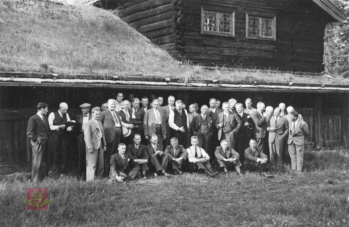 Generalforsamlingsreise i Elverum  27. juni 1936.  Middag på Glomdalsmuseet Elverum.  
39 menn i gruppe foran tømmerbygning med torvtak.