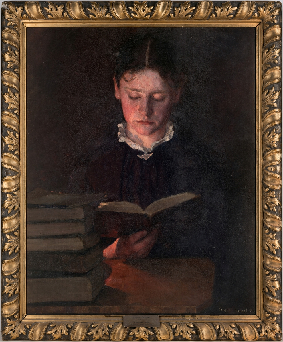 Portrett hode en face, lesende i en oppslått bok, en bokstabel på bordet til venstre., med en lyskilde bakenfor, varmt lampelys over kvinnens høyre ansiktshalvdel. Avskåret ved midjen.