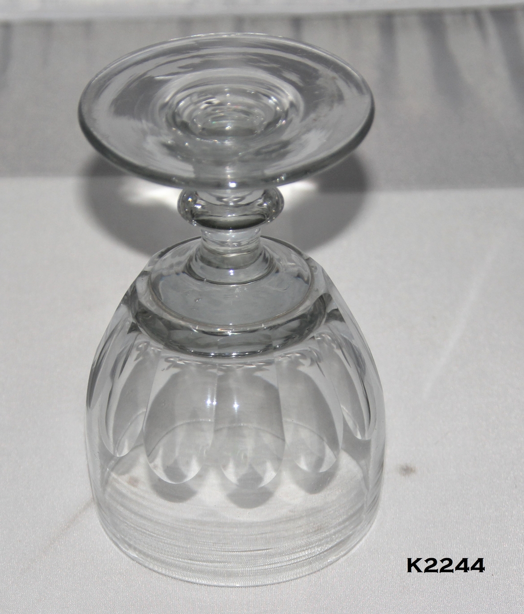 Mjneralvannglass, 2 stk.
Glass, klart. Smalt glass med oppoverskrånende sider.
Tykk bunn, med ti fasettslipninger over nedre del, svakt innsvunget nederst.