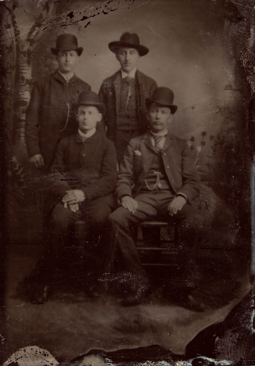 Studioportrett av fire menn med hatt.
