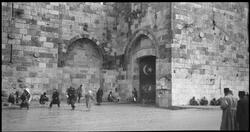 Mennesker foran en murbygning, muligens i Jerusalem.