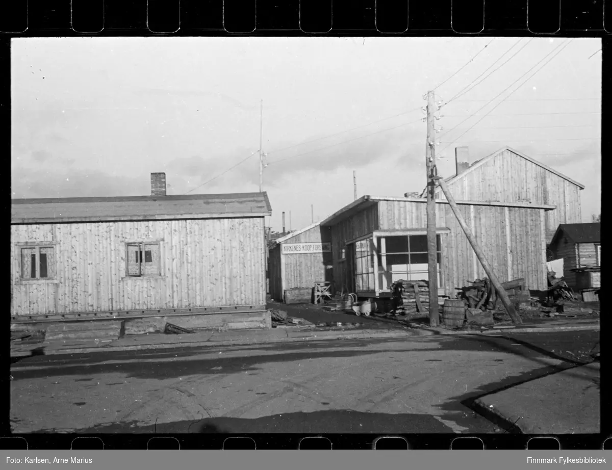 Foto av bygget til Kirkenes Kooperative forening, foto antagelig tatt i perioden 1945 - 1949

Utenfor bygget kan man se en barnevogn 