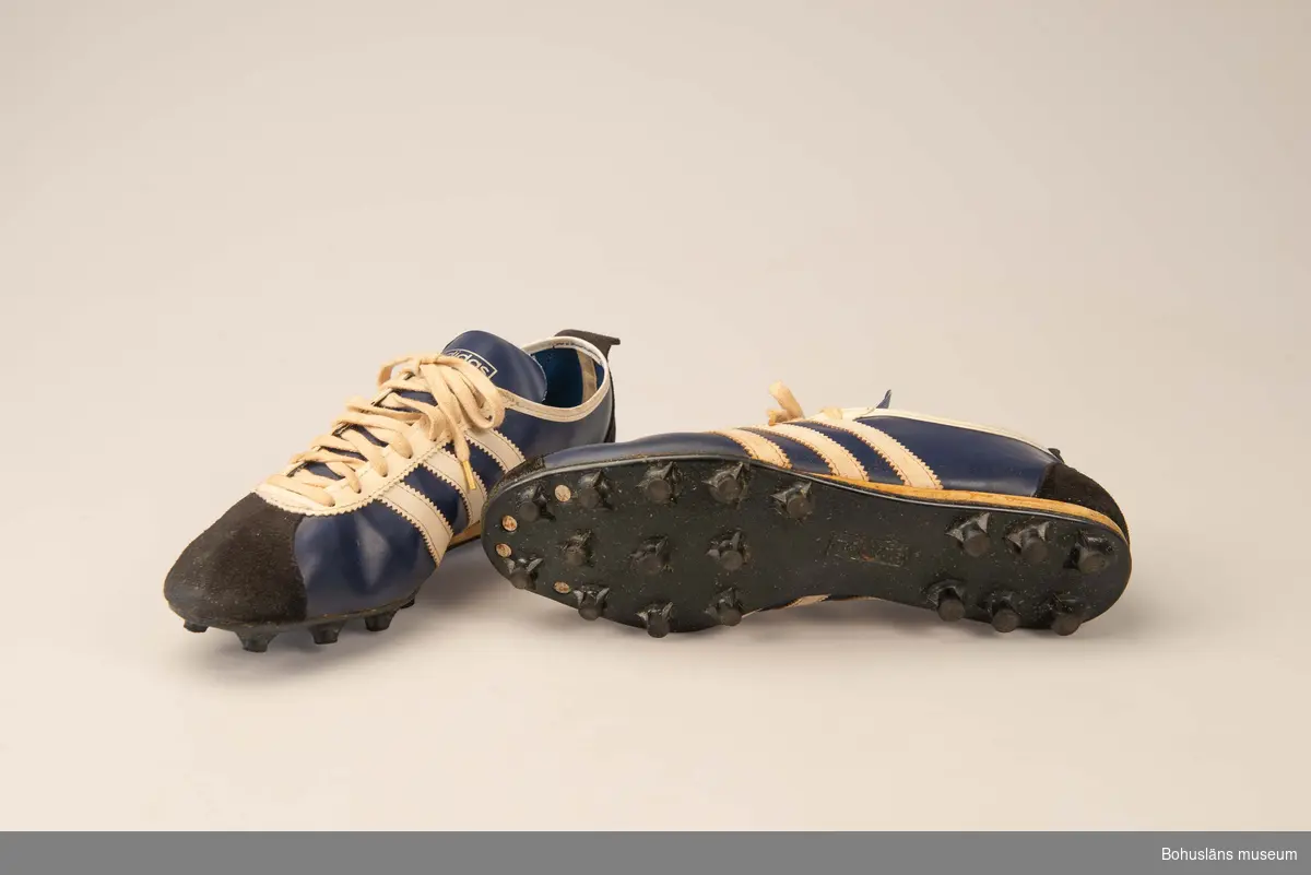 410 Mått/Vikt !L.28,5 B.10 H.9 CM
010 Fotbolls-skor. Blåvita med dobbar.Skinnförstärkningar.
