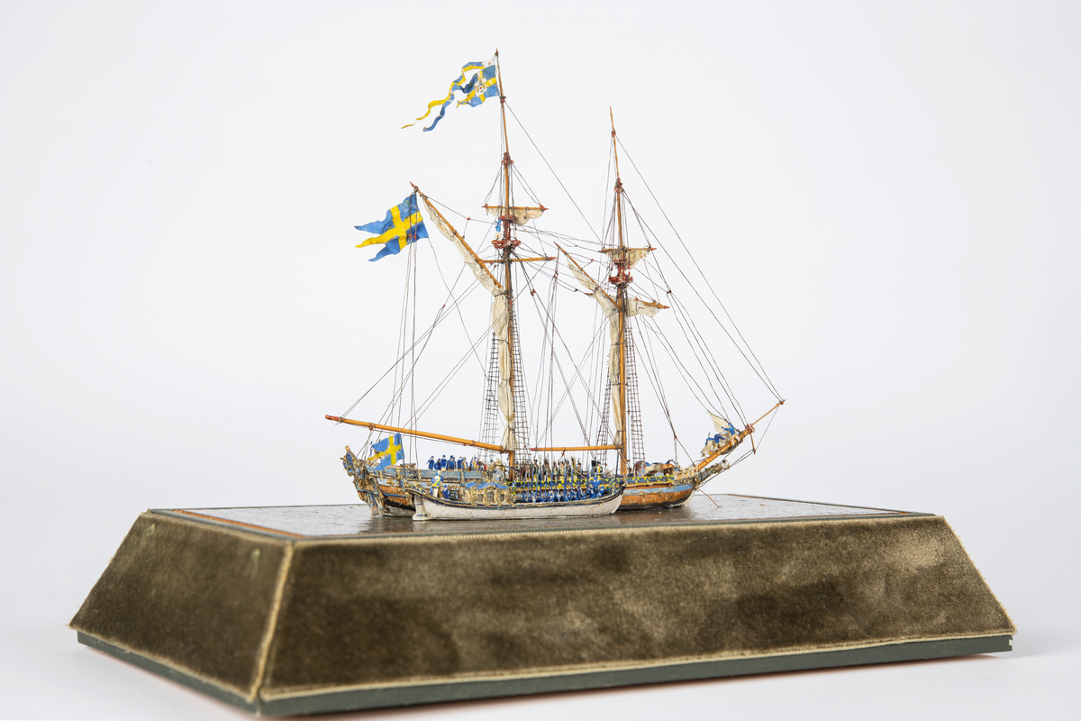 Modellen föreställer AMPHION med kungaslupen WASA - ORDEN liggande långsides på gemensam platta med figurer på däck.