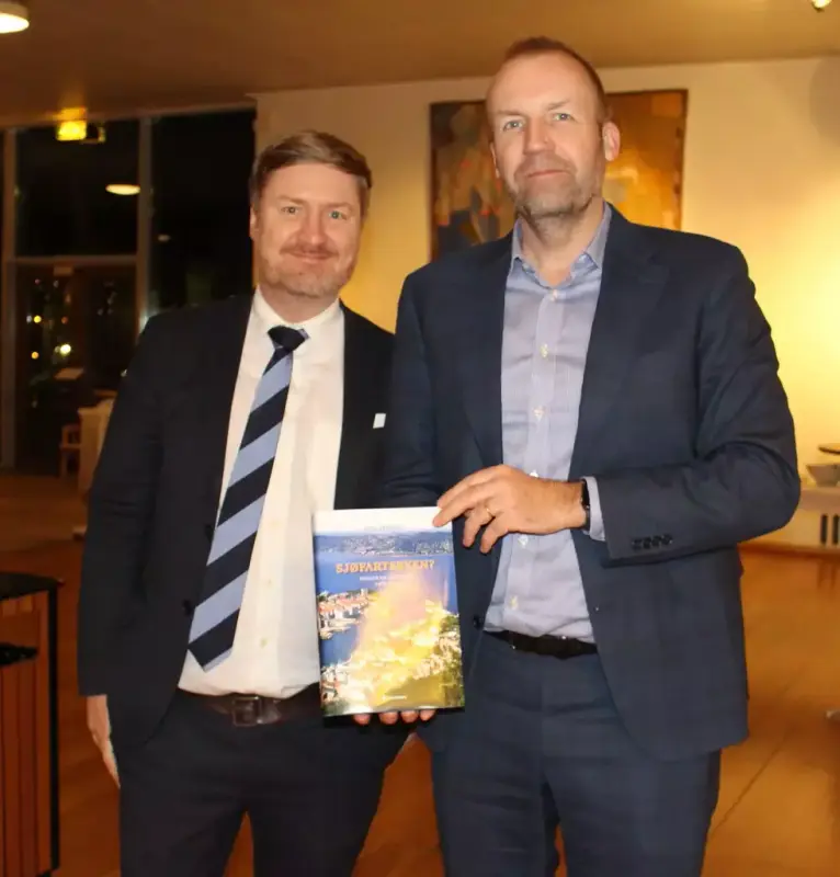 Redaktør Knut André Karlstad fra Gyldendal (til venstre) og forfatter Stig Tenold viser stolt fram et eksemplar av boken.