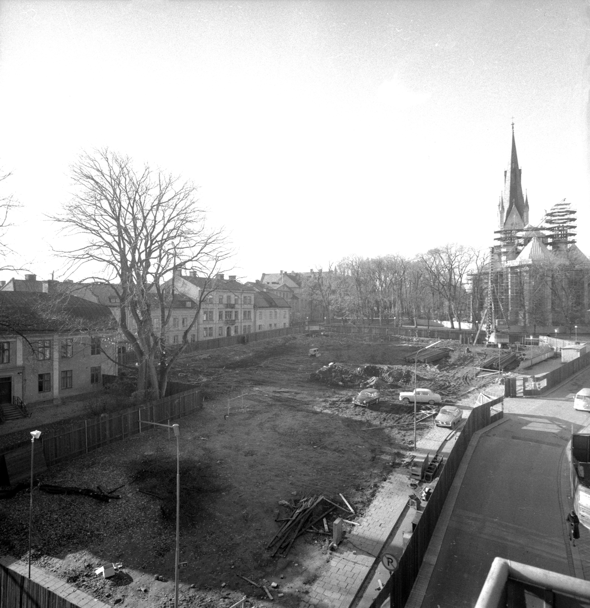 Vy över kvarteret Ambrosia inför byggnationen av det nya sociala nämndhuset. Notera skedet i bakgrunden, där domkyrkans östtorn är under uppbyggnad.