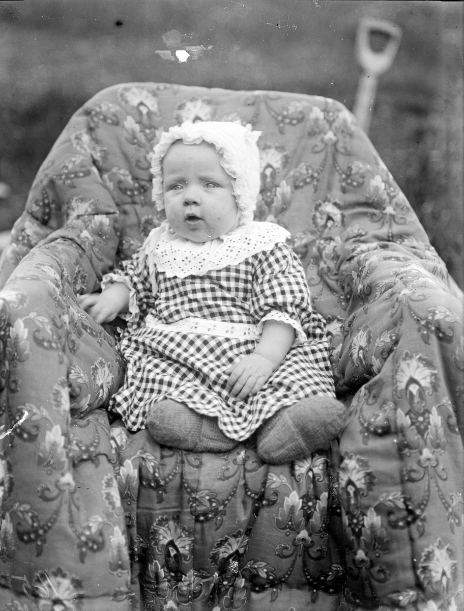 Bilde viser portrett av liten beby i lenestol.

Fotosamling etter Øystein O. Jonsjords (1895-1968), Tinn.