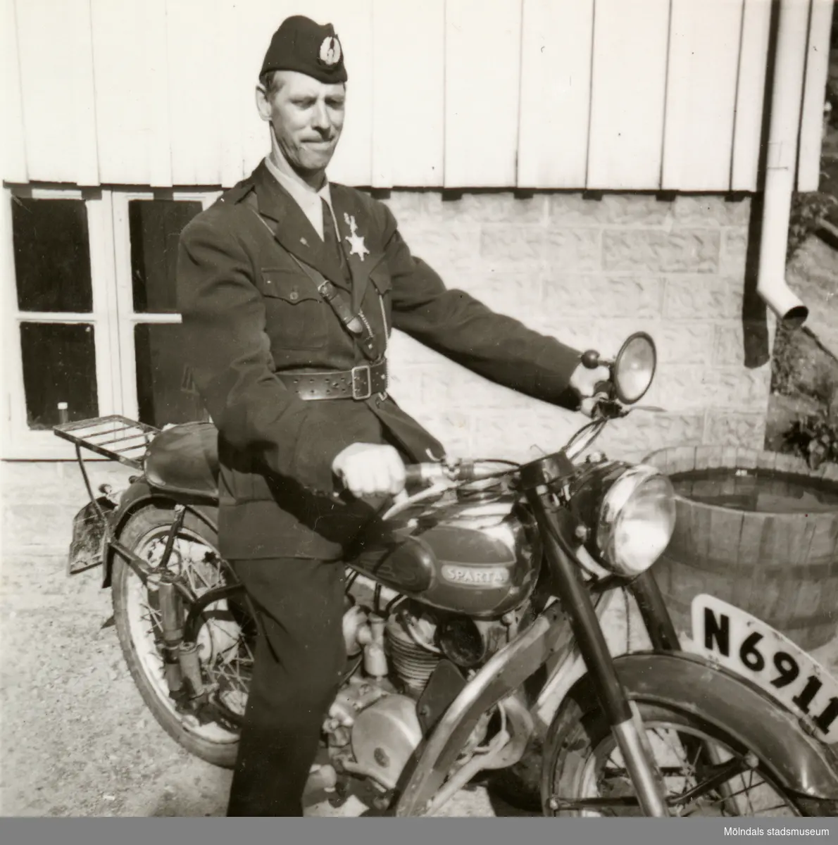 Fritjof (elev boende på Stretereds skolhem) iförd polisuniform, sitter på en motorcykel i Stretered, 1940-tal. Han fick ibland "hjälpa" polisen.