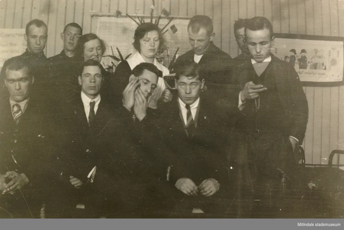 Julfirande på arbetshemmet för elever boende på Stretereds vårdhem år 1925. Nio män (elever) och två kvinnliga vårdarinnor står uppställda framför en julgran. Arbetshemmet låg nära personalbostäderna.